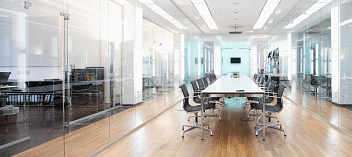 Modern glass walled conference room with long table