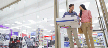Couple walking out of department store holding boxes