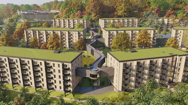 Birds eye view rendering of apartment buildings with green roofs and fall foliage backdrop.