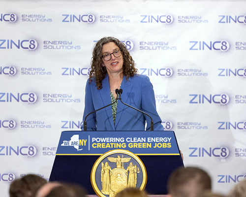Speaker at podium with Zinc8 step-and-repeat backdrop.