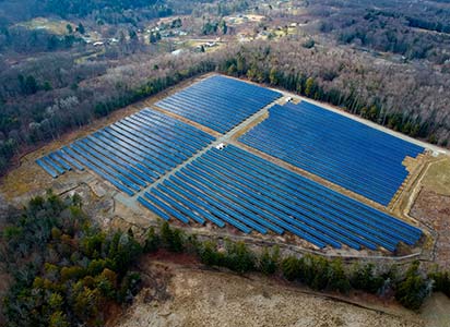 Arial view of a field filled with solar panels on Conklin Solar Farm.