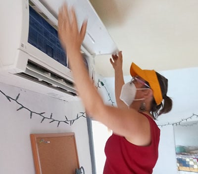 Person inspecting HVAC unit.