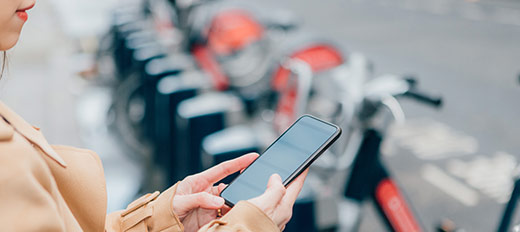 woman on her phone infront of e-bikes
