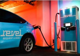 A Revel electric vehicle being charged at a Revel charging station.