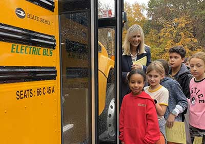children getting on an electric school bus