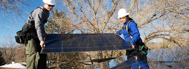 two workers installing a solar panel