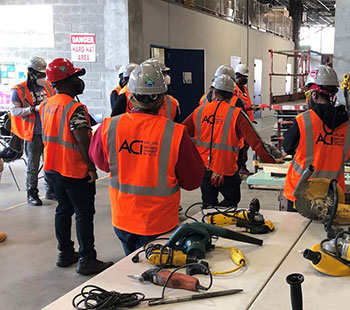 A group of ACI workers in hard hats and safety vests.