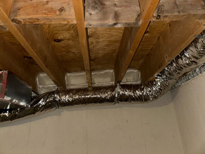 Grey rectangles of spray foam insulation on basement rim joists