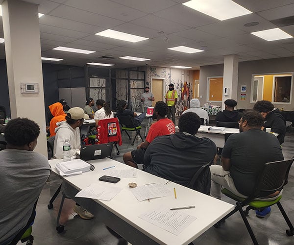 Trainees seated around tables in a SEAT Center room.