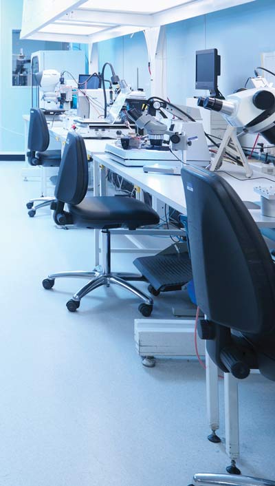 Medical lab with rolling chairs and equipment setup at work stations.