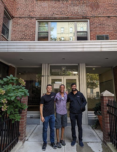 Three Sherman Terrace project participants posing together in front of the building.