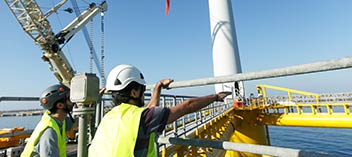 Offshore wind technicians in from of wind turbine