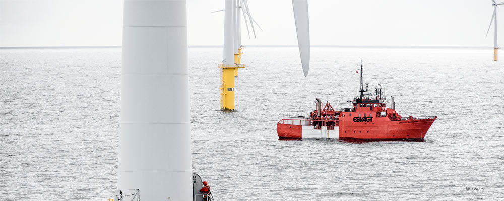 Boat traveling through offshore wind farm