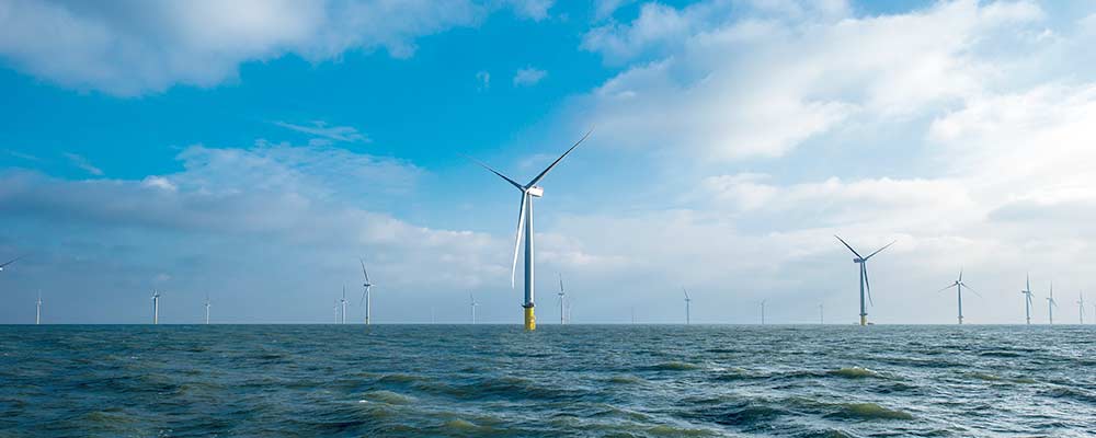 View of offshore wind farm from water to horizon